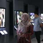 Pengunjung mengamati foto-foto bertajuk "Setelah Gelombang Reda" yang dipamerkan di Museum Tsunami Aceh, Kamis (6/2/2025). (Foto: UNIC Indonesia)