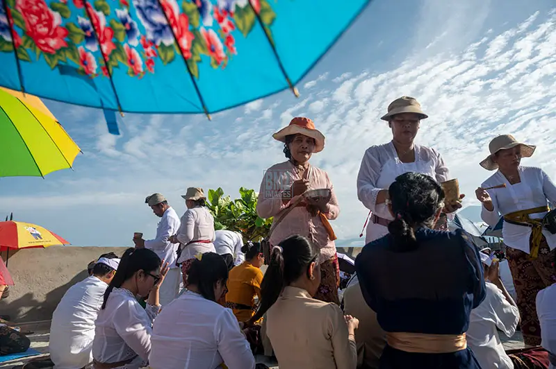 Pengurus memercikkan tirta suci kepada umat usai upacara persembahyangan Melasti di Pura Melasti, Pantai Dupa, Palu, Kamis (27/3/2025). (FbmzIMAGES/Basri Marzuki)