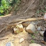 Aparat Polsek Kulawi melewati jalan yang longsor di salahs atu titik yang longsor di Pipikoro. (Foto: Humas Pores Sigi)