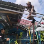 Personel Satgas Madago Raya memperbaiki atap rumah warga korban puting beliung di Desa Tabalu, Pos, Senin (7/4/2025). (Foto: Humas Satgas Madago Raya)