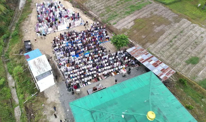 Foto udara suasana pelaksanaan shalat Idul Adha di halaman Masjid Raodhatul Jannah kawasan transmigrasi Bulu Pontu Jaya, Desa Sidera, Sigi, Sulawesi Tengah, Jumat (6/6/2025). (bmzIMAGES/Basri Marzuki)