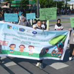 Sejumlah remaja membawa spanduk dan pamplet saat long march pada deklarasi pencegahan perkawinan usia anak di lapangan Vatulemo, Palu, Sulawesi Tengah, Minggu (13/7/2025). (bmzIMAGES/basri marzuki)