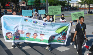 Sejumlah remaja membawa spanduk dan pamplet saat long march pada deklarasi pencegahan perkawinan usia anak di lapangan Vatulemo, Palu, Sulawesi Tengah, Minggu (13/7/2025). (bmzIMAGES/basri marzuki)
