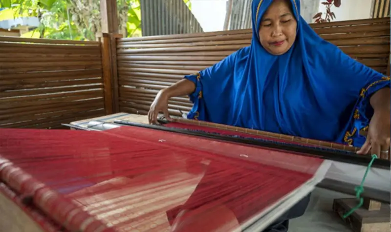 perajin menyelesaikan pembuatan kain tenun Donggala dengan alat tenun bukan mesin (ATBM) di Desa Towale, Banawa Tengah, Donggala, Sulawesi Tengah, Rabu (30/6/2021). (© bmzIMAGES/basri marzuki)