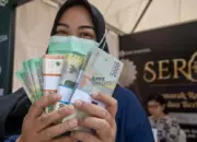 Warga menunjukkan uang rupiah pecahan kecil yang baru saja ditukarkan di kawasan layanan bersama penukaran uang di Palu, Sulawesi Tengah, Selasa (2/4/2024). (©bmzIMAGES/Basri Marzuki)