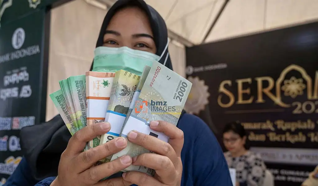 Warga menunjukkan uang rupiah pecahan kecil yang baru saja ditukarkan di kawasan layanan bersama penukaran uang di Palu, Sulawesi Tengah, Selasa (2/4/2024). (©bmzIMAGES/Basri Marzuki)